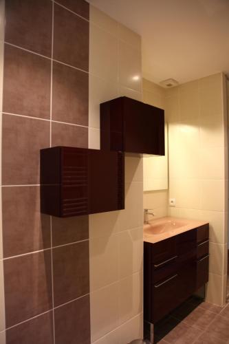 baño con lavabo y pared de azulejos en Maison avec piscine privative, en Nyons