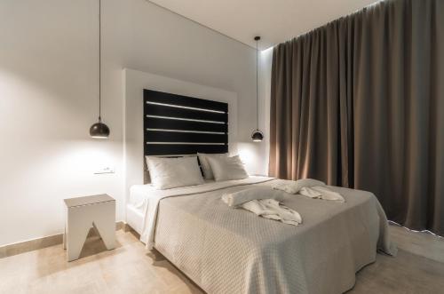 1 dormitorio blanco con 1 cama con manta blanca en Belussi Exclusive Suites, en Kypseli