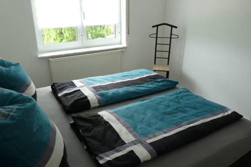 two beds sitting next to a window in a room at Ferienwohnung Schwarzwaldrand in Nagold