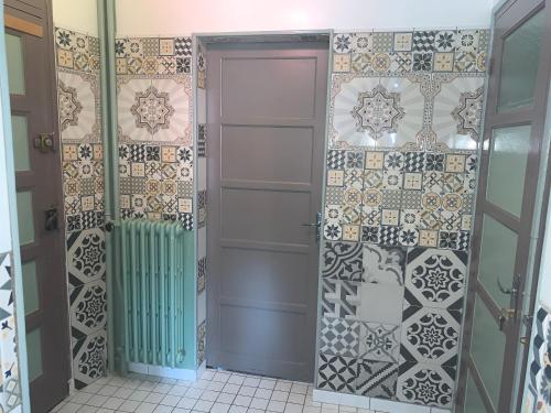 baño con puerta y pared de azulejos en Gîte Arcis sur Aube en Arcis-sur-Aube