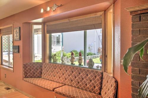 a living room with a couch in a window at Sunny Home with Patio Less Than 10 Mi to Lake Coeur dAlene in Post Falls