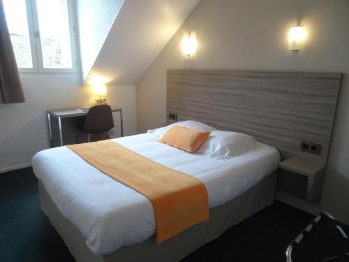 - une chambre avec un grand lit et une tête de lit en bois dans l'établissement Hôtel Ker Izel Saint-Brieuc Centre Historique, à Saint-Brieuc