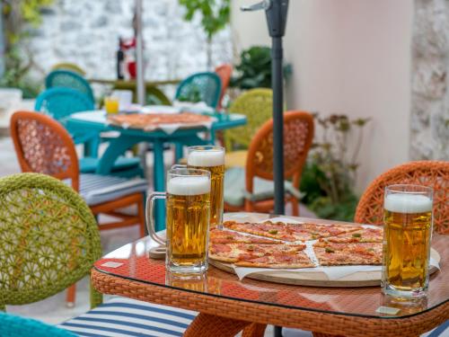 a table with two pizzas and two glasses of beer at Apartments Windrose in Kotor