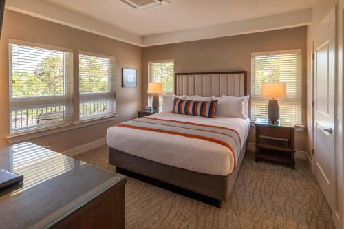 a bedroom with a bed and two windows at Lakeside Lodge Clemson in Clemson