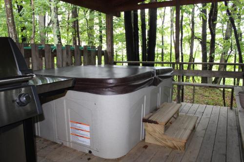 a large barbecue on a deck with a bench at Country Road Cabins in Hico