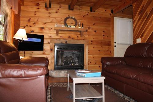 a living room with two couches and a fireplace at Country Road Cabins in Hico