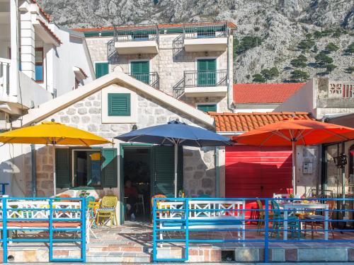 a group of tables with umbrellas in front of a building at Apartments Windrose in Kotor