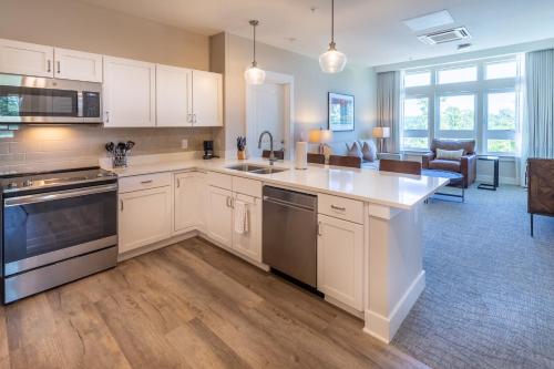 a kitchen with white cabinets and a living room at Lakeside Lodge Clemson in Clemson