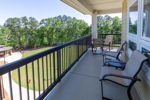 a screened porch with chairs and a view of a park at Lakeside Lodge Clemson in Clemson