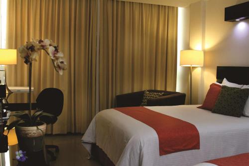 a hotel room with a bed and a chair at Hotel Poza Rica Centro in Poza Rica de Hidalgo
