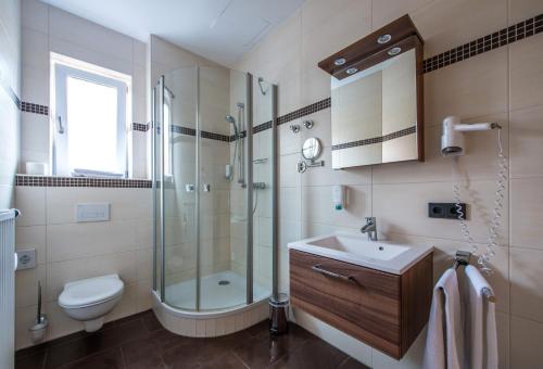 a bathroom with a shower and a toilet and a sink at Hotel Gasthof Fenzl in Steinberg