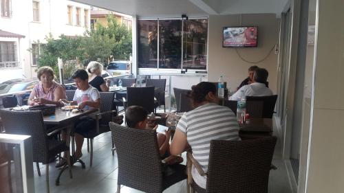 a group of people sitting at tables in a restaurant at Altunakar 1 Hotel in Didim