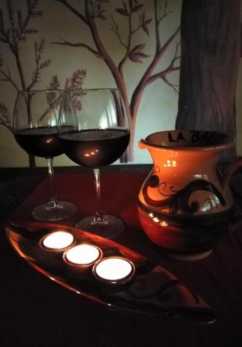 two glasses of wine and a vase on a table at La Baita Suite in Sicignano degli Alburni
