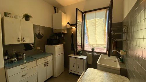 a small kitchen with white cabinets and a window at CA' ROMANTICA - BIG APPARTMENT at ACCADEMIA in Venice