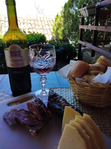 a table with a bottle of wine and a plate of cheese at La Baita Suite in Sicignano degli Alburni