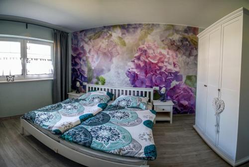 1 dormitorio con 1 cama y papel pintado con motivos florales en Ferienwohnung Gräfe, en Stöckey