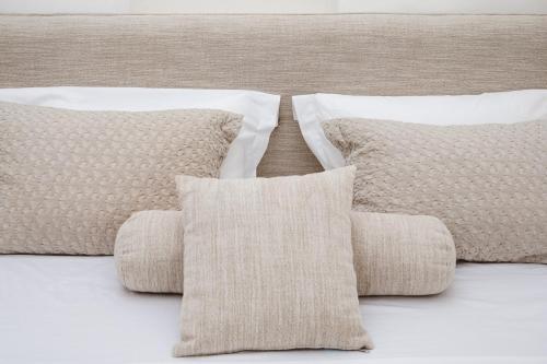a group of pillows sitting on top of a bed at Pnoe in Mýkonos City