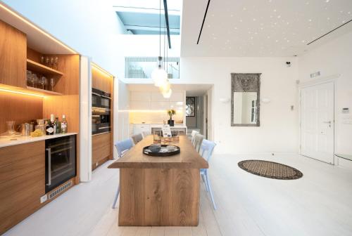 a kitchen and dining room with a large wooden table at Pnoe in Mýkonos City