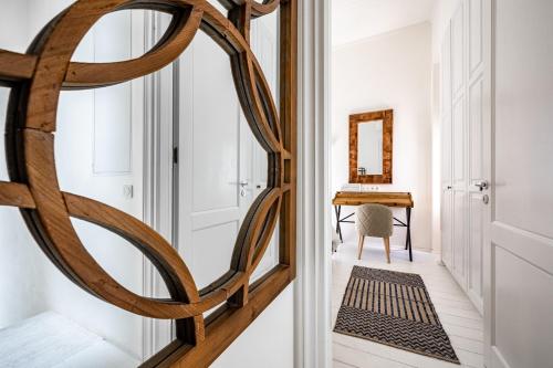 a hallway with a large woodenorthole door with a mirror at Pnoe in Mýkonos City