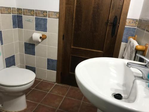 a bathroom with a white toilet and a sink at Casa Rural Cortijo La Ajedrea in Siles