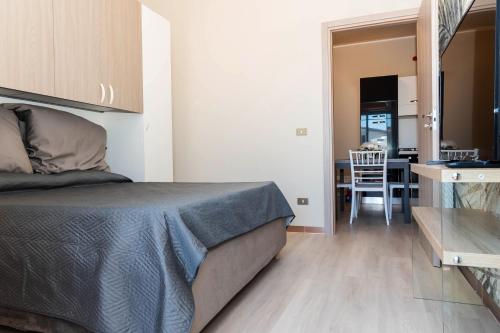 a bedroom with a bed and a dining room at Fiumicino Dream & Fly in Fiumicino