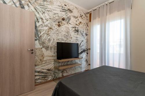 a bedroom with a tv on a wall at Fiumicino Dream & Fly in Fiumicino
