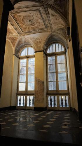 an empty room with windows and a ceiling at Le coccole in Genova