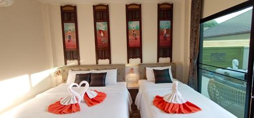 two beds with red and white dresses on them at Sila Thai Pool Villa2 in Ao Nang Beach
