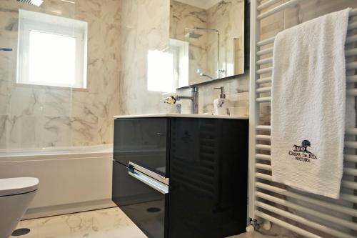 a bathroom with a black cabinet and a sink at Casal da Rita Natura in Santarém