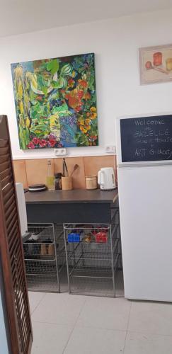 un escritorio en una habitación con una pintura en la pared en Gazelle Guest House and Art Gallery, en Ruffec