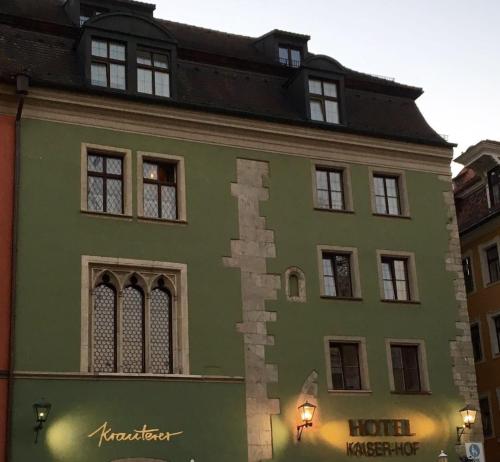 un gran edificio verde con una casa en Hotel Kaiserhof am Dom, en Regensburg