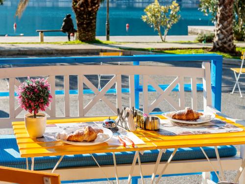 a yellow table with two plates of food on it at Apartments Windrose in Kotor