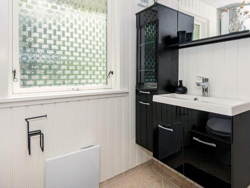 - une salle de bains en noir et blanc avec lavabo et fenêtre dans l'établissement Holiday home Toftlund VIII, à Toftlund