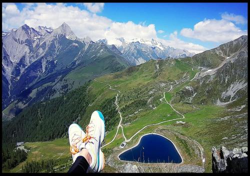 una persona sentada en la cima de una montaña mirando un lago en Haus Wibmer, en Matrei in Osttirol