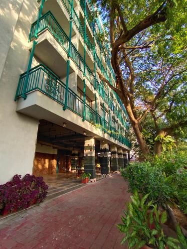a building with a balcony on the side of it at Bougainvilla Apartment in Surat