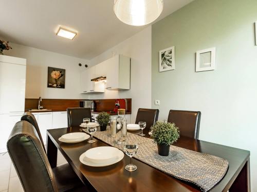 a dining room table and chairs with wine glasses on it at VacationClub - Myśliwska 60 Apartament 1 in Karpacz