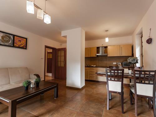 a kitchen and living room with a table and chairs at VacationClub - Nadrzeczna 2B Apartament 4 in Karpacz
