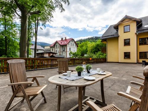 a wooden table and chairs on a patio at VacationClub - Nadrzeczna 2B Apartament 4 in Karpacz