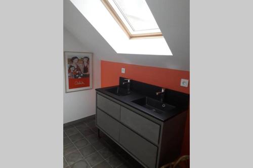 a bathroom with a sink and a skylight at La petite brise in Plouër-sur-Rance