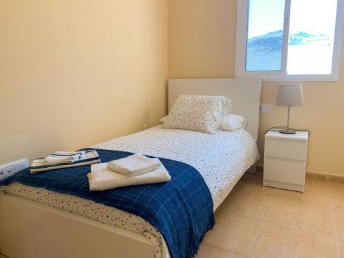 1 dormitorio con 1 cama con toallas en Miramar 9, en San Sebastián de la Gomera