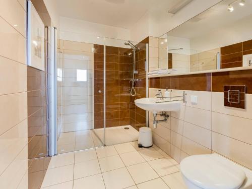 ein Bad mit einer Dusche, einem WC und einem Waschbecken in der Unterkunft VacationClub - Olympic Park Apartament A605 in Kołobrzeg