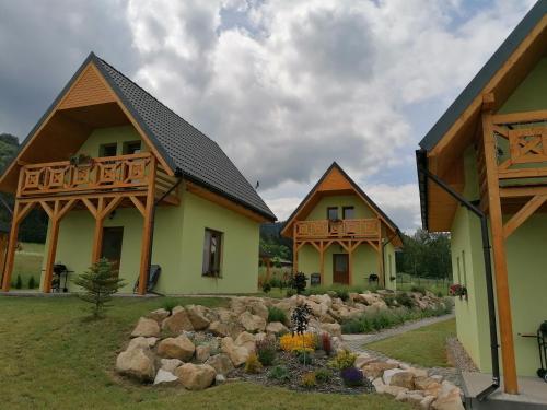 a couple of houses with rocks in a yard at Domki pod Derkaczem in Radków