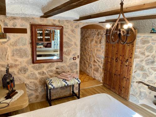 a room with a stone wall with a chair and a mirror at Finca Ses Fontanelles in Andratx