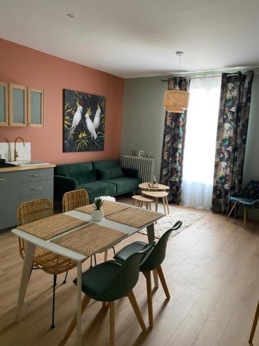 un salon avec un canapé vert et une table dans l'établissement Villa st Louis 2, à Cabourg