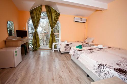 two beds in a room with a desk and a window at Familly hotel Randevu in Kranevo