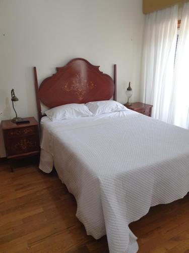 a bedroom with a large bed with a white blanket at hostel do Ermal in Vieira do Minho