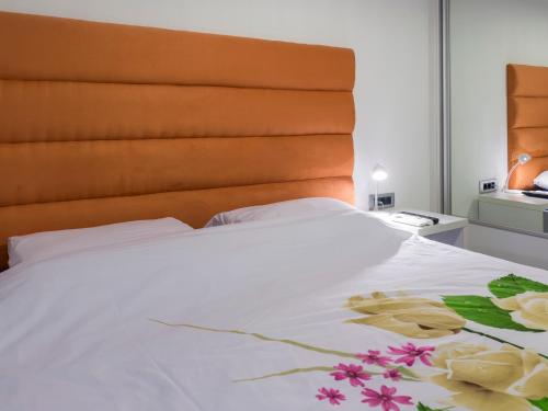 a bed with white sheets and flowers on it at Apartments Windrose in Kotor
