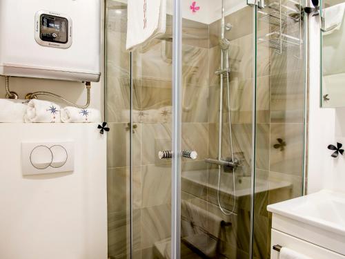 a shower with a glass door in a bathroom at Apartments Windrose in Kotor