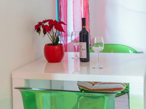 a white table with a bottle of wine and two glasses at Apartments Windrose in Kotor