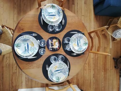 une table en bois avec des plaques bleues et blanches dans l'établissement Le charme de l ancien entre mer et ville, au Havre